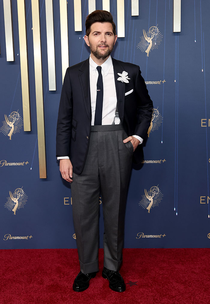 Man wearing stylish high-waist trousers and navy blazer on the red carpet showcasing best-dressed fashion at the 2025 Emmys