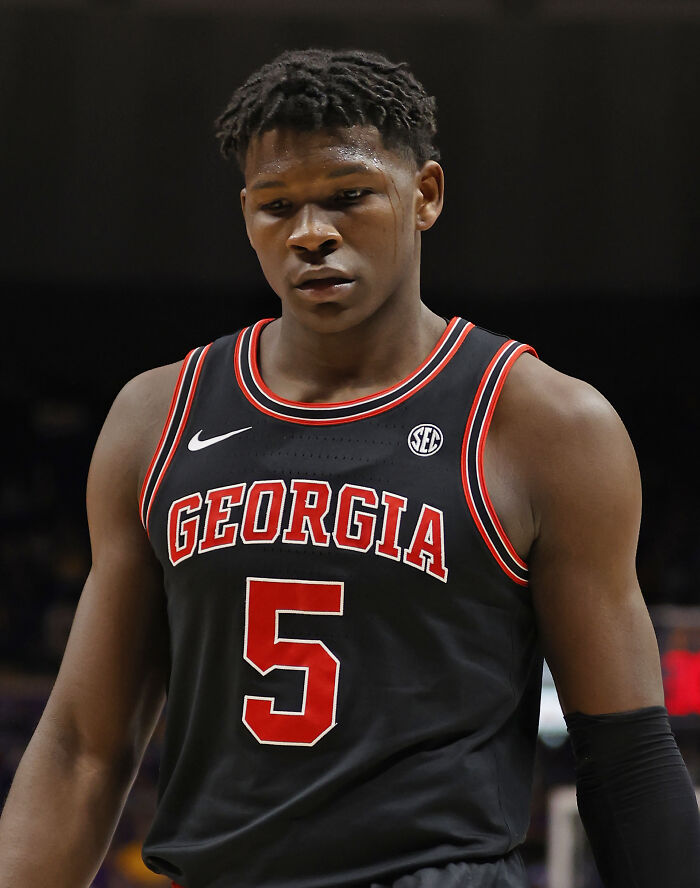 College basketball player in Georgia uniform, focused during a game, representing highest paid athletes 2025.