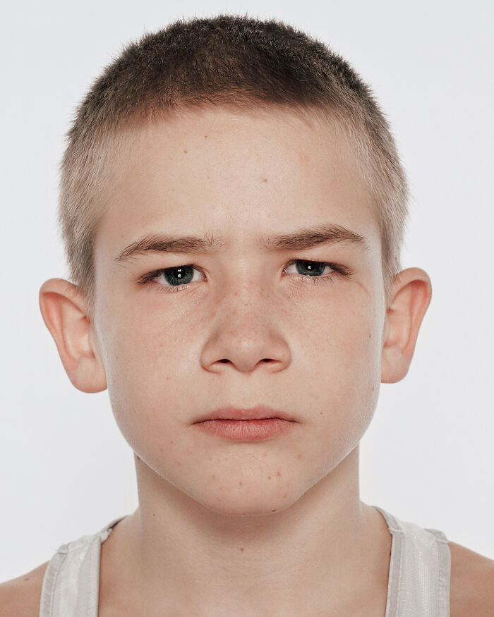 Close-up of a young boxer with a determined expression before his first match in powerful photographs series.