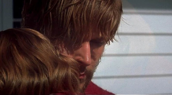 Close-up of two people embracing, illustrating a heartfelt moment related to beloved movie tropes in cinema.