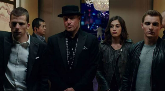 Group of serious characters in dark clothing illustrating popular movie tropes featured in the ultimate beloved movie tropes poll.