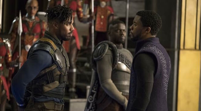 Three men in futuristic armor having a serious conversation, illustrating popular movie tropes in action scenes.