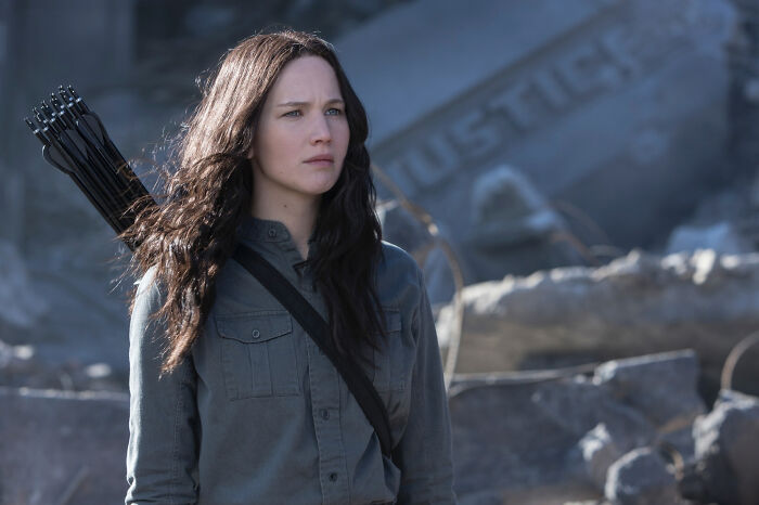 Female character in a movie wearing a gray shirt with a quiver of arrows, representing well-written female characters breaking stereotypes.