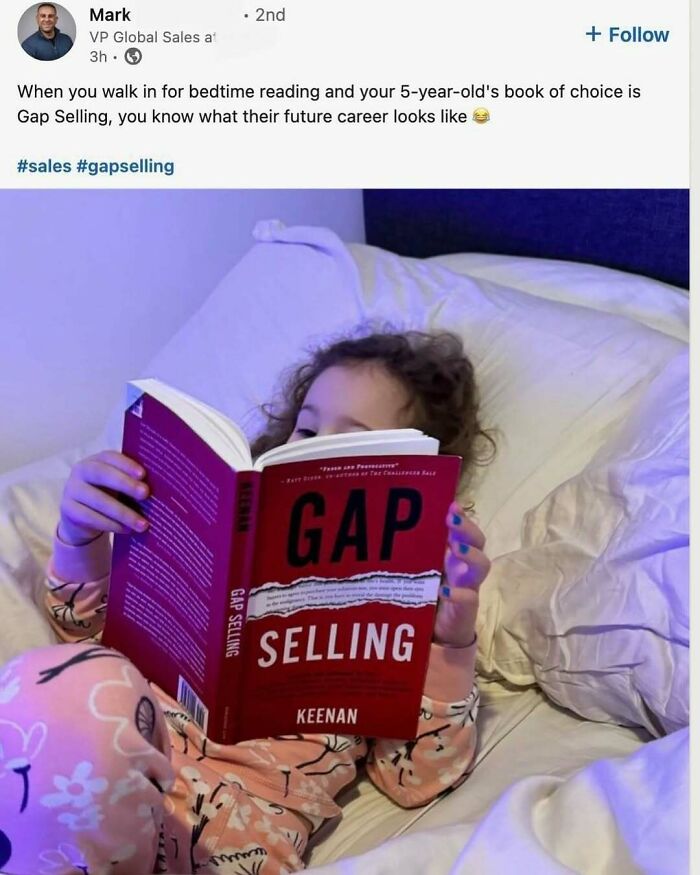 Child in pajamas reading a book about sales, illustrating people consumed by hustle culture and losing touch with real life.