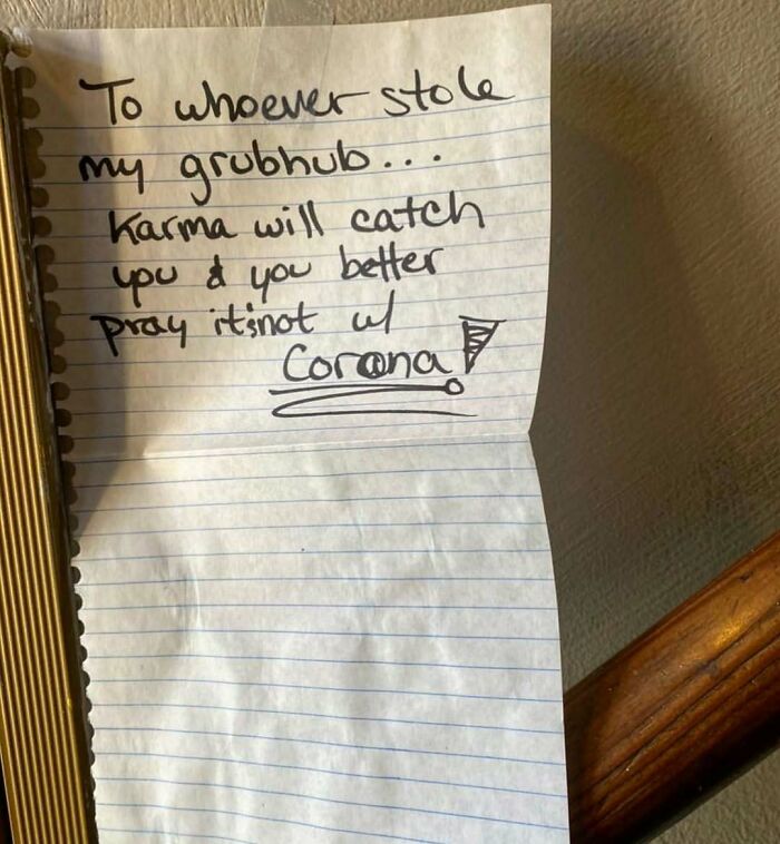 Note about stolen Grubhub with a warning about karma and coronavirus written on lined paper taped to a wall, showing unbearable neighbors issues.