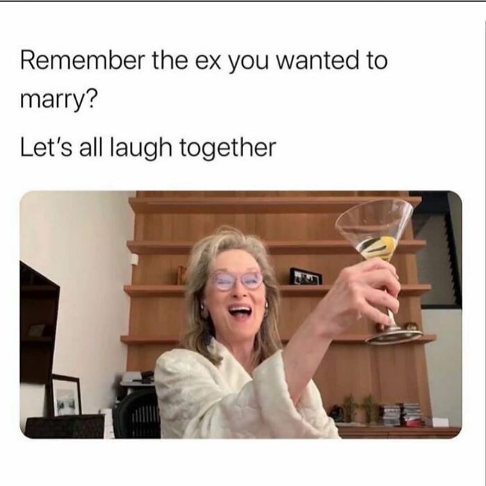 Woman in glasses raising a glass and laughing, representing funny dating memes about past relationships and love life.