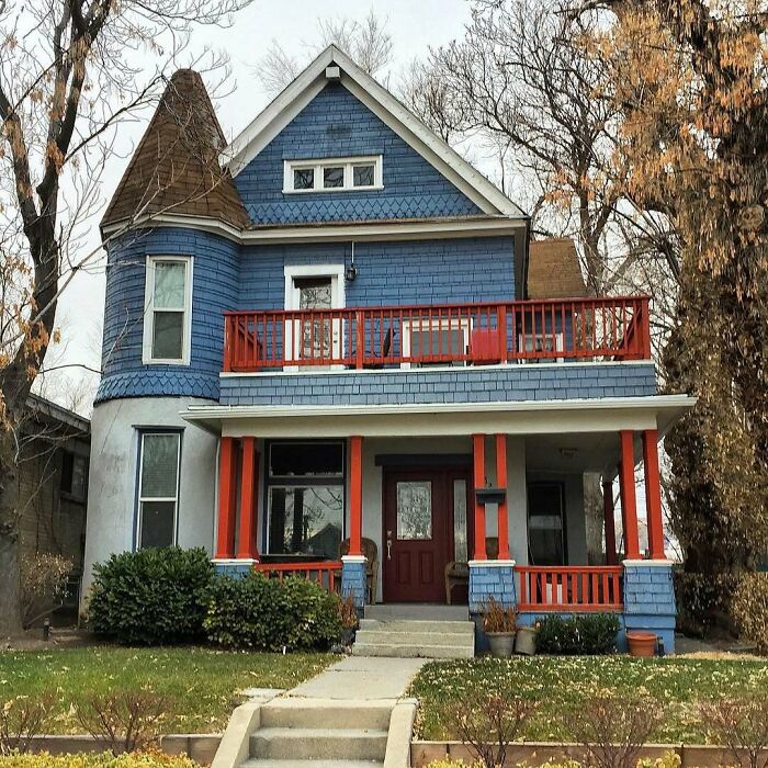 Blue and red charming old home with a turret and spacious porch, perfect for lovers of adorable old homes.