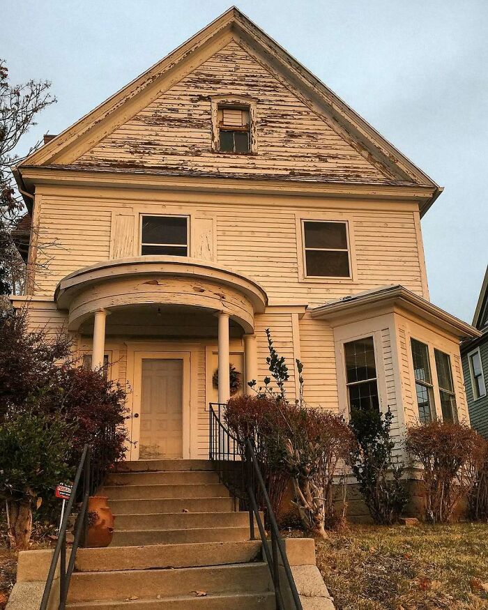 Old homes with charming vintage architecture featuring weathered wood siding and a cozy front porch with columns.