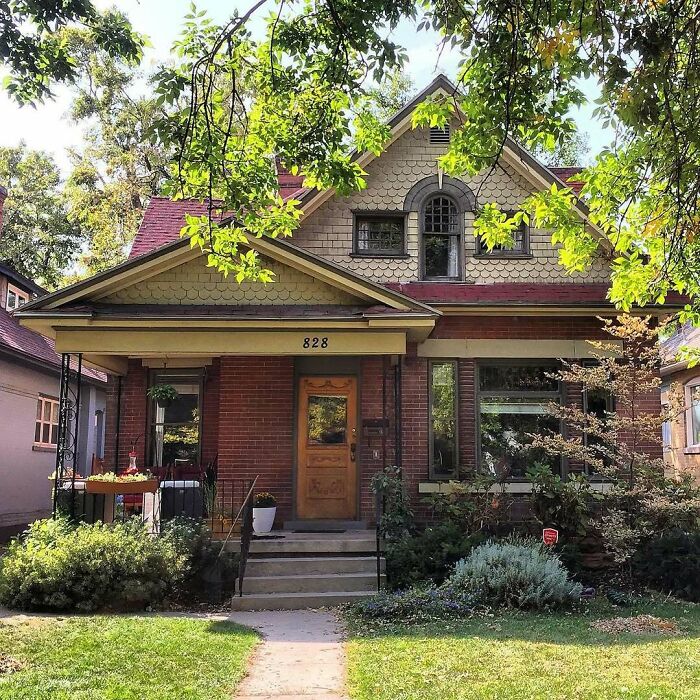 Charming old home with brick exterior, wooden door, and lush greenery, showcasing the appeal of adorable and lovely old homes.