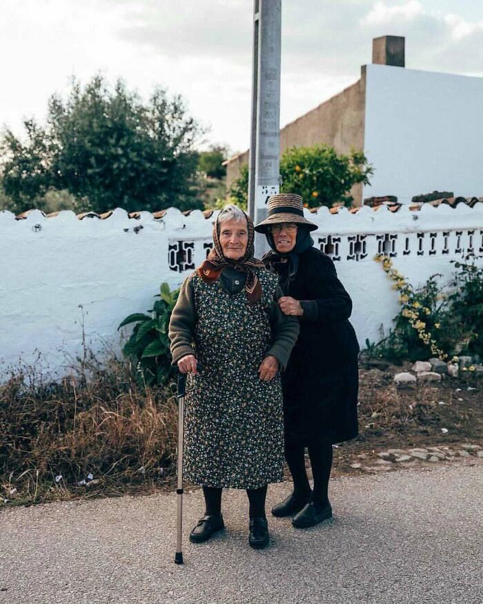 Two cool and stylish grandparents wearing traditional outfits outdoors, showcasing unique and fashionable elder fashion.