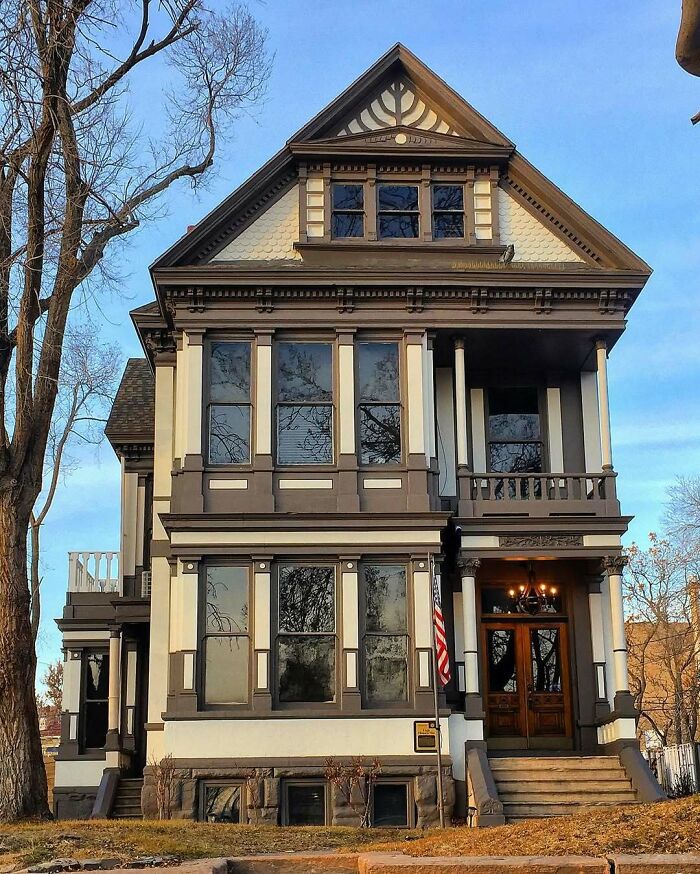 Victorian-style old home with large windows, a porch, and detailed wood trim, showcasing adorable and lovely old homes.