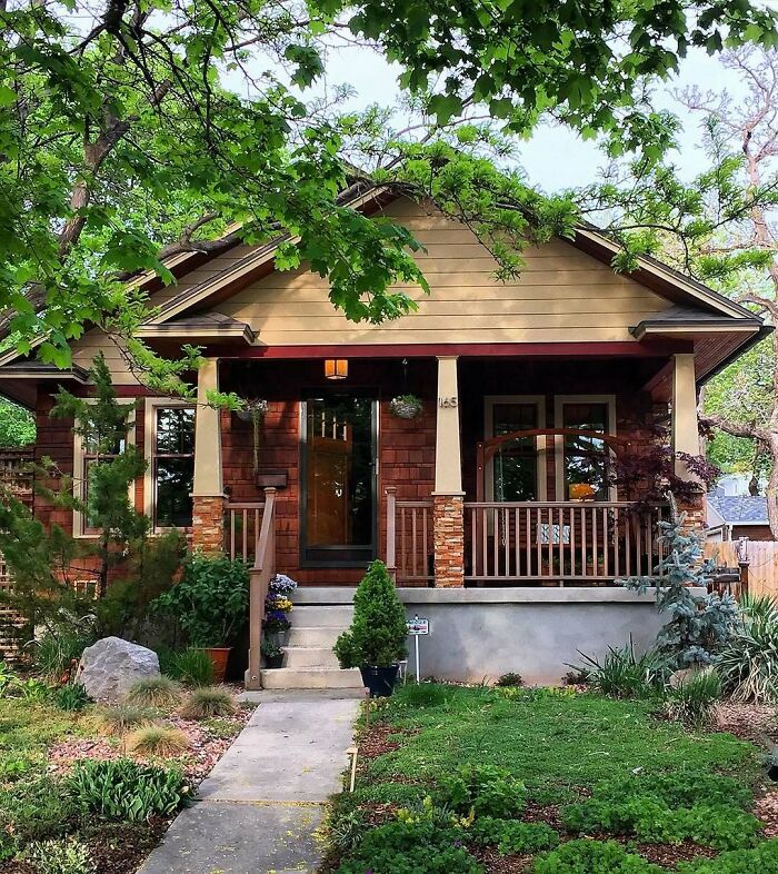 Cozy charming old home with a wooden porch and lush greenery, perfect for anyone wanting to move into lovely old homes.