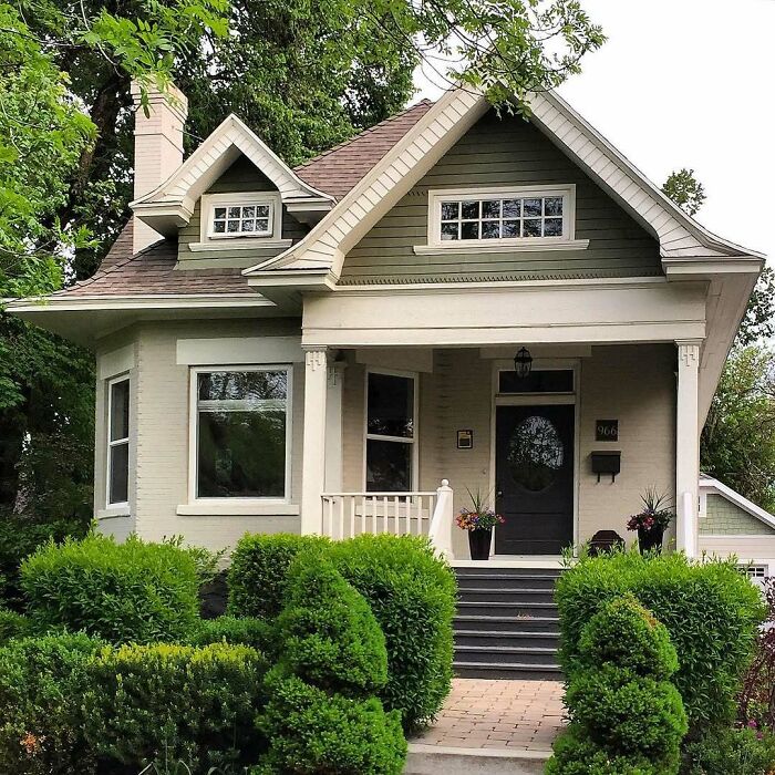 Cozy charming old home with lush green landscaping and inviting front porch, perfect for lovers of adorable old homes.