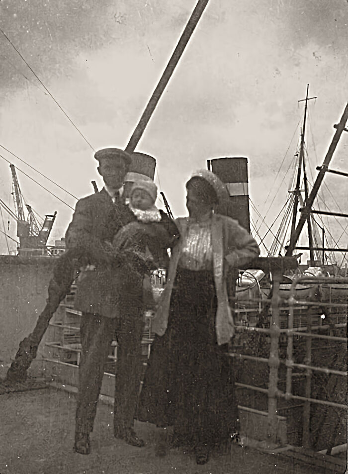 Vintage family photo on the Titanic deck with crew member, woman, and baby, showcasing rare historical Titanic moments.