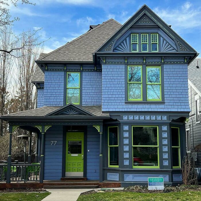 Victorian style old home with blue siding and green window frames, showcasing charming and adorable architectural details.