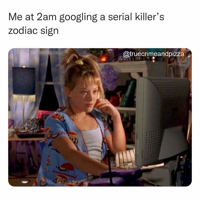 Person in colorful pajamas using a desktop computer late at night, relating to true crime memes and binge-watching.