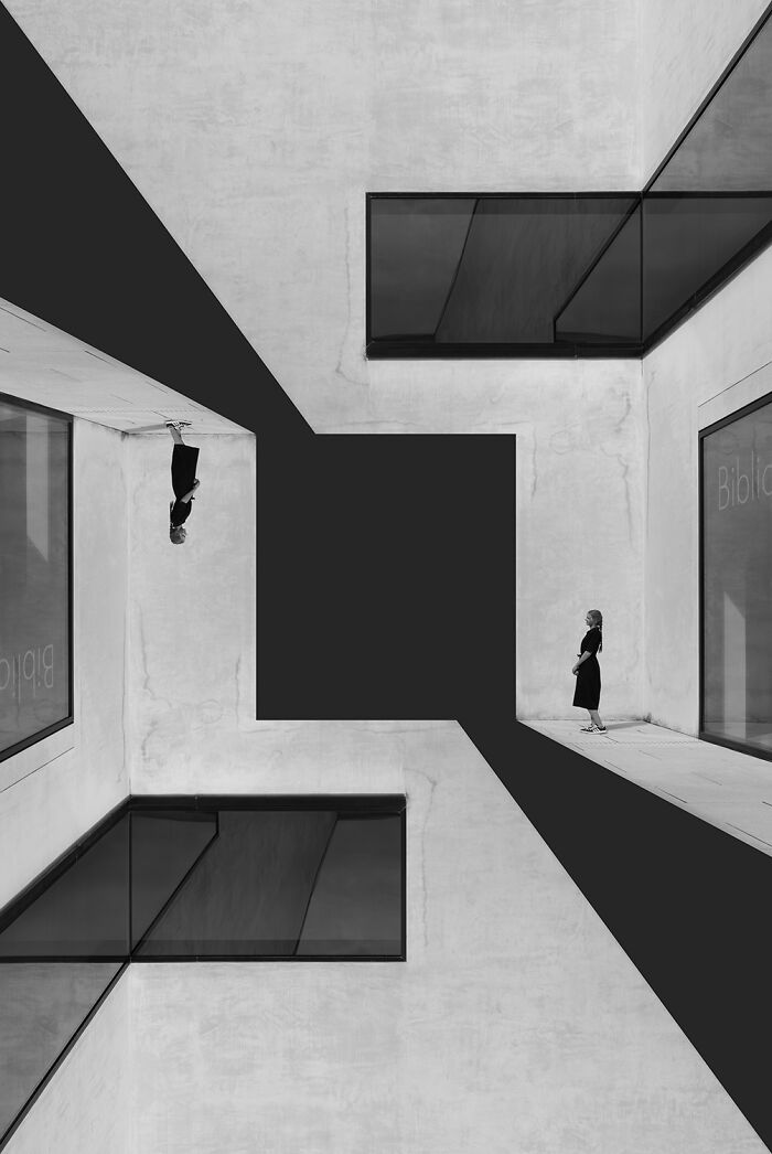 Minimalist black-and-white photo with geometric architecture and a woman standing, showcasing award-winning black-and-white photography.