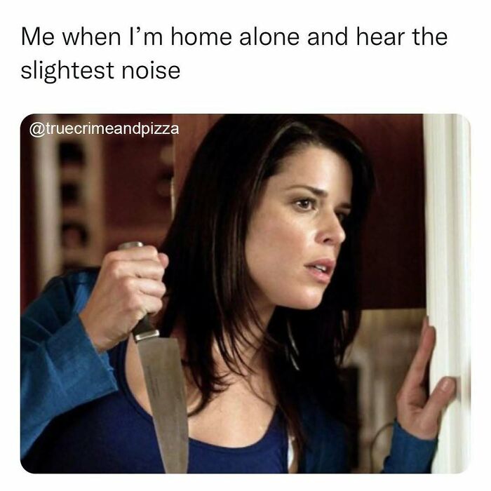 Woman holding a knife cautiously peeking around a door, illustrating a true crime binge-watcher’s reaction to a noise at home.