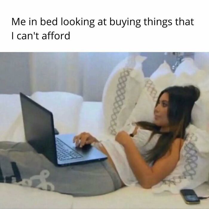 Woman lying in bed using a laptop, representing funny insomnia memes about restless thoughts and sleepless nights.