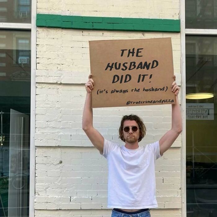 Man in sunglasses holding a true crime meme sign that says the husband did it, referencing true crime self-care humor.