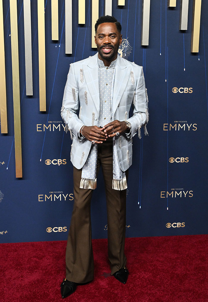 Hombre con traje de diseñador y detalles de moda en la alfombra roja de los Emmys 2025, destacado en estilo y vestimenta.