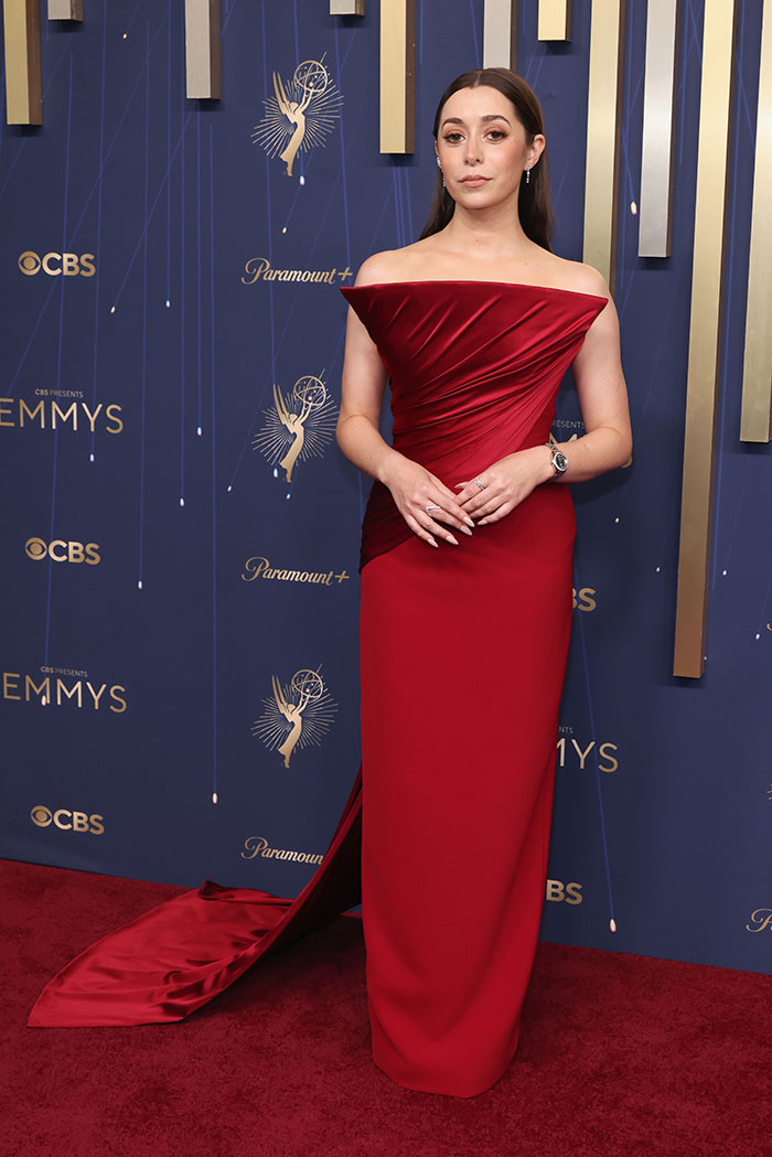 Mujer vestida con un elegante vestido rojo en la alfombra roja de los mejores y peores vestidos en los Emmys 2025.