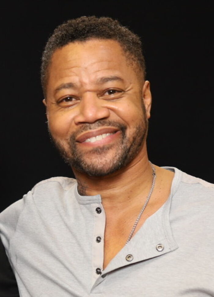 Smiling man wearing a light gray shirt and chain necklace, representing people who ran into celebrities and had worst experiences.