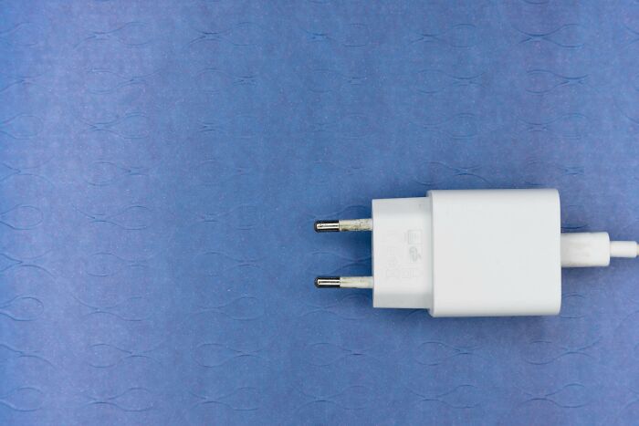 White electrical plug adapter on a textured blue surface symbolizing tricky deal breakers across life situations.