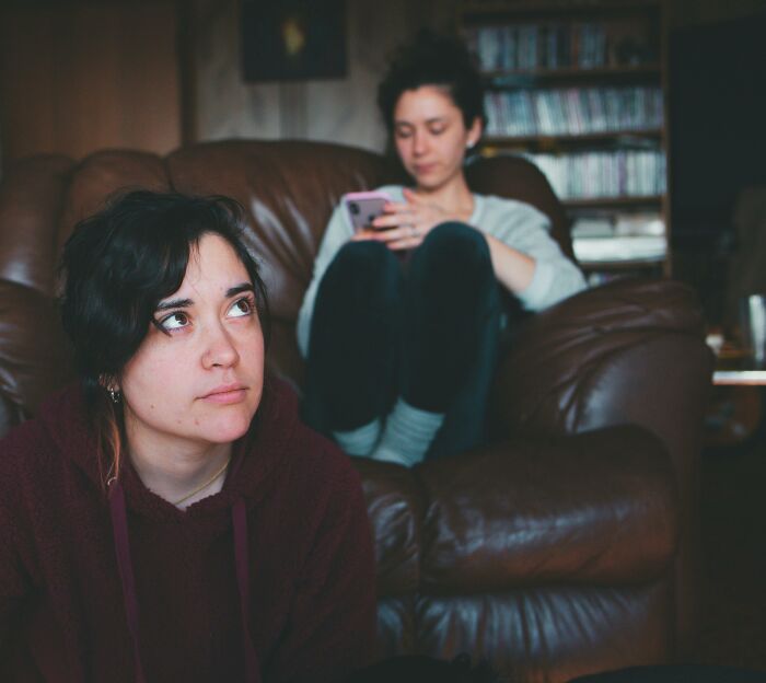 Two women in a living room showing emotional distance, illustrating tricky deal breakers in relationships.