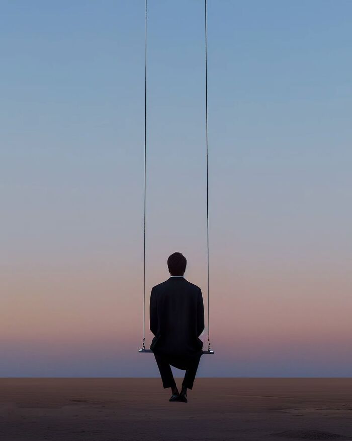Person in a black suit sitting alone on a minimalist swing at dusk with a peaceful and dreamy sky background.