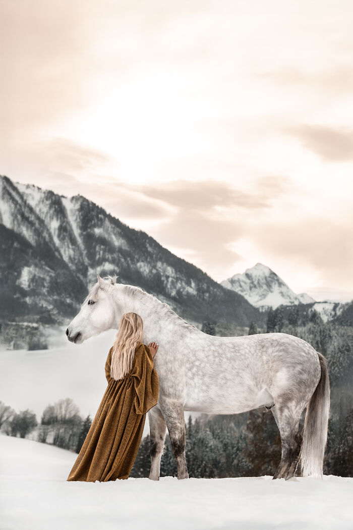 Woman with long blonde hair and tattoos sitting in a field beside a horse in a creative pet photo winning award.