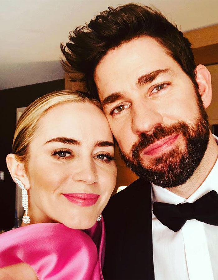 Emily Blunt close-up with a man, smiling at the camera indoors, sparking plastic surgery rumors.