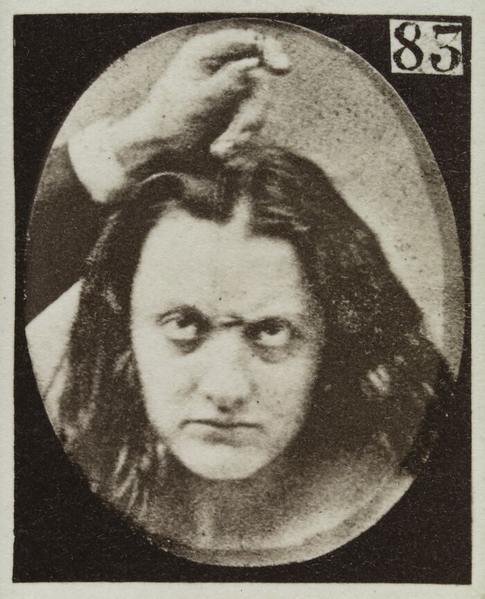 Black and white 19th century facial expressions experiment photo showing a woman with a disturbing intense look.
