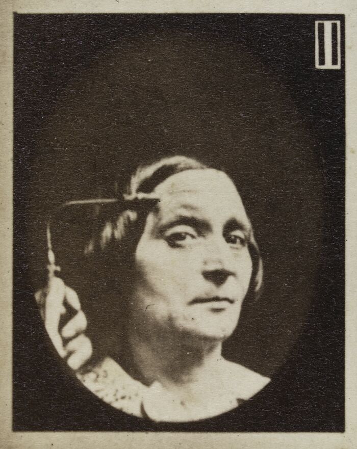 19th century facial expressions experiment showing a woman with a neutral face holding a tool near her temple