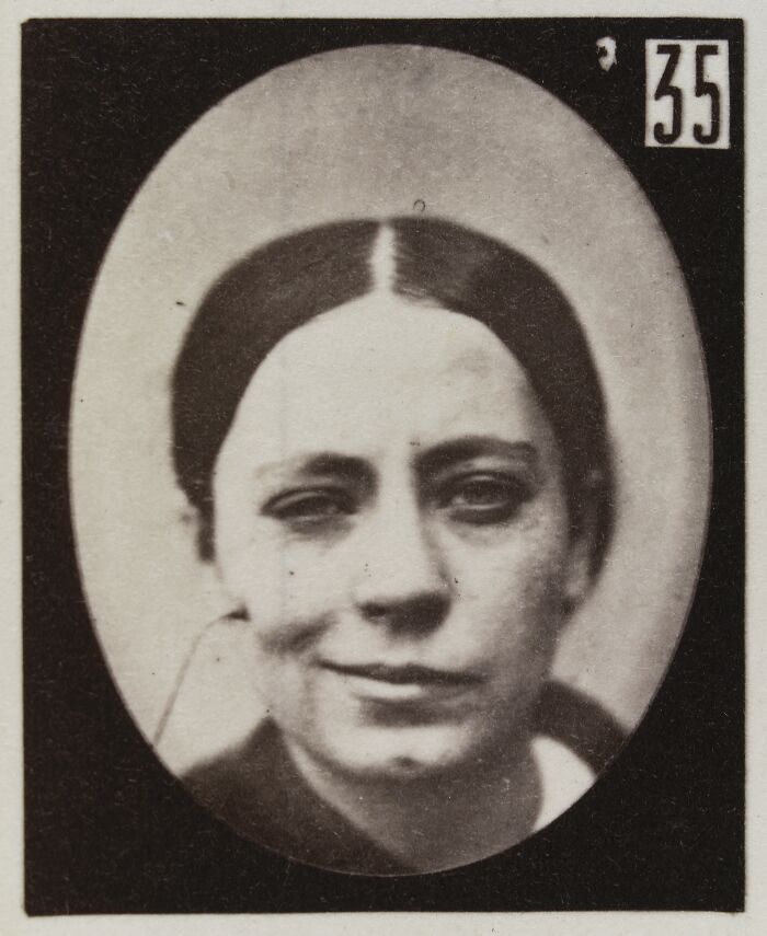 Black and white 19th century photo showing a woman's facial expression from a historical facial expressions experiment.