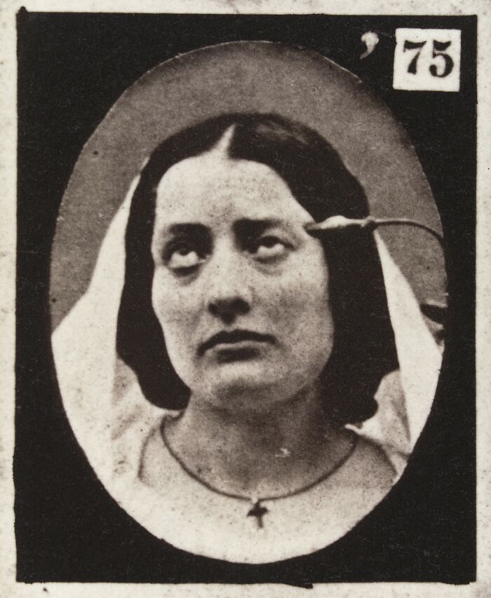 19th century facial expressions experiment photo of woman with unusual expression and cross necklace close-up portrait