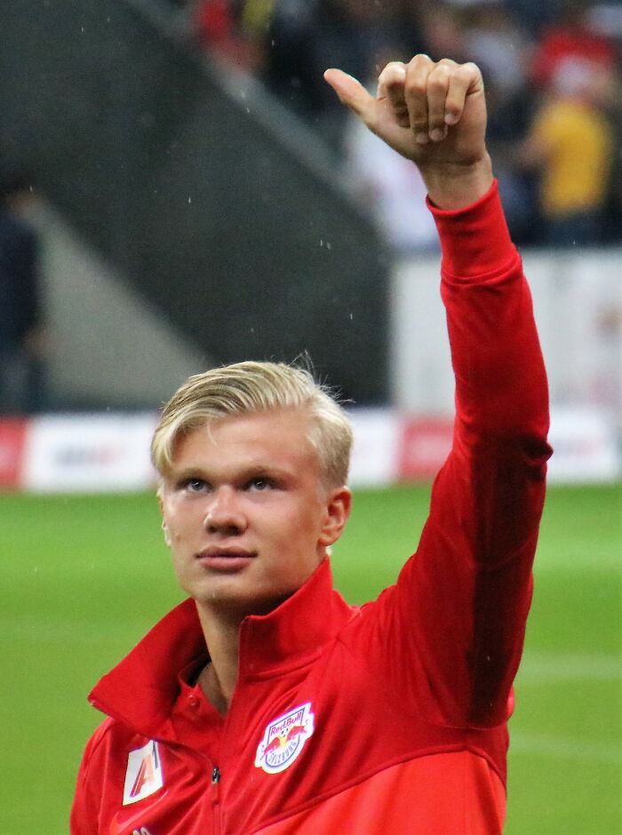 Young athlete in red sportswear giving a thumbs up on the field, representing highest paid athletes 2025.