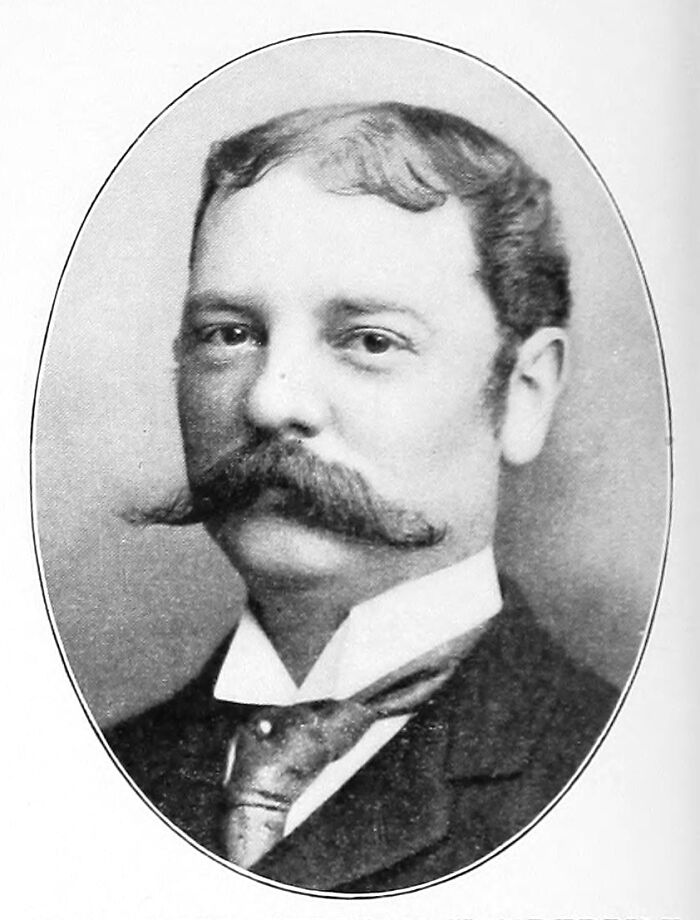 Vintage black and white portrait of a man with a large mustache representing the world’s richest family legacy.