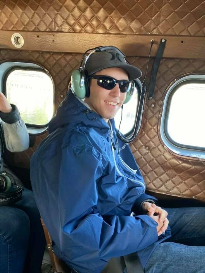 Young man wearing headphones and sunglasses inside a small aircraft, unrelated to FBI director under fire and Charlie Kirk case.