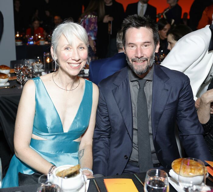 Keanu Reeves and his girlfriend smiling at a formal event as she breaks her silence on marriage rumors.