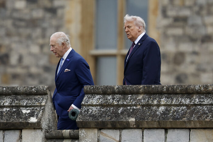 King Charles displaying subtle signs of impatience with Donald Trump during a formal state visit outdoors.