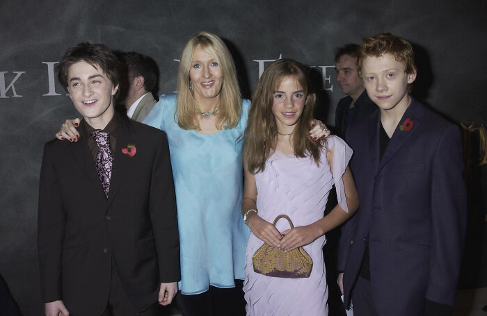 J.K. Rowling with young actors at an event, highlighting the context of Emma Watson's trans feud silence.