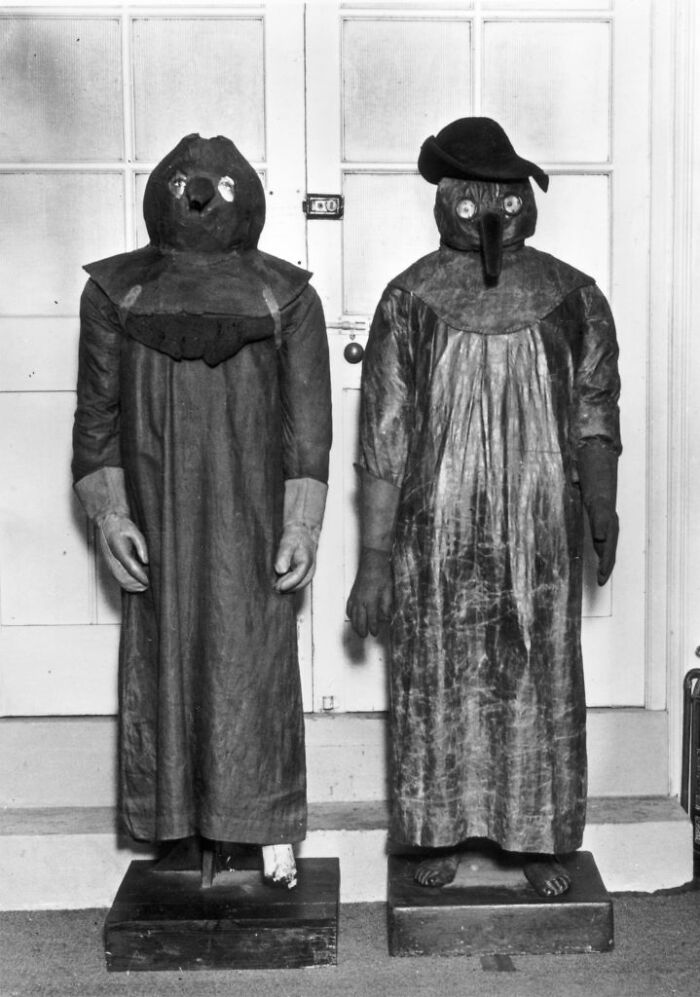 Old-school medical pics showing two mannequins in vintage plague doctor costumes with bird-like masks.