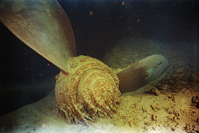 Rust-covered propeller of the Titanic wreck resting on the ocean floor, part of rare historical photos of the Titanic.