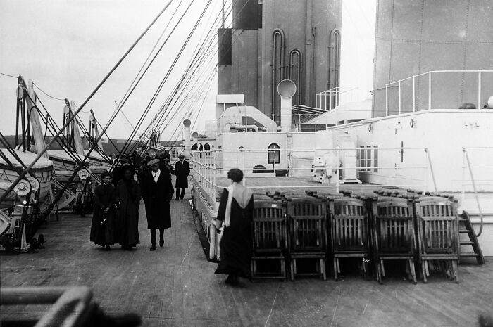 Passengers walking on the deck of the Titanic in a rare historical photo showing life aboard the ship before its voyage.