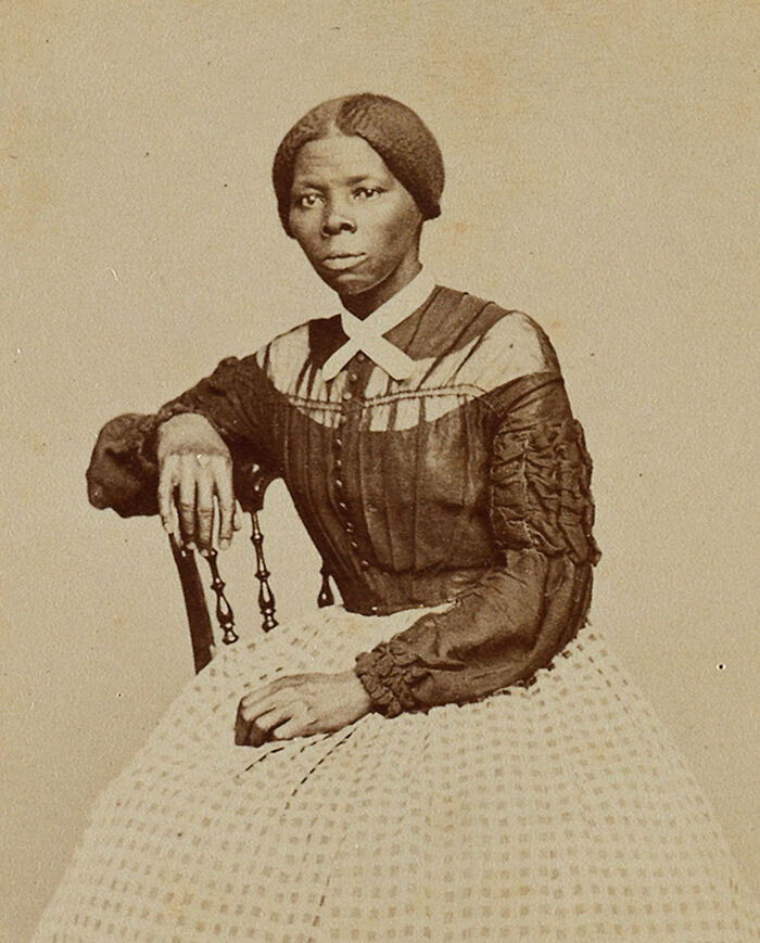 Harriet Tubman seated in period dress, an American folk hero known for her role in the Underground Railroad.