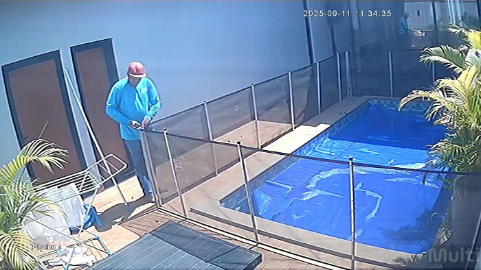 Pool attendant in blue shirt near fenced pool area during a rescue of a blind dog from drowning. Pool attendant in blue shirt near fenced pool area during a rescue of a blind dog from drowning.