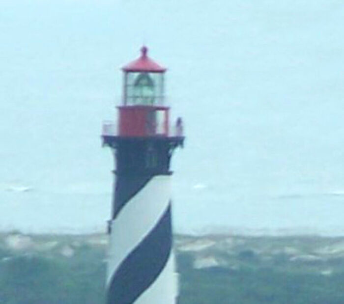 Lighthouse with distinctive black and white spiral pattern on the tower, a photo that seems normal until you learn the mystery.