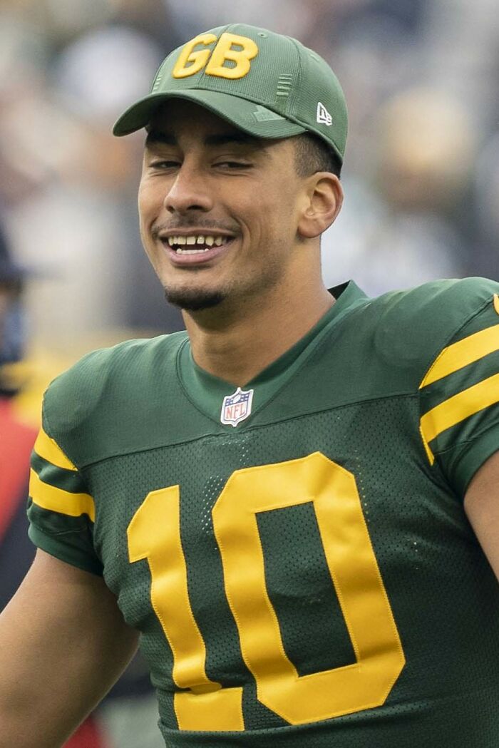 Athlete in green and yellow football uniform smiling during a game, representing highest paid athletes 2025.