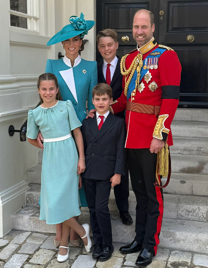 The Duke and Duchess of Cambridge posing with their three children outdoors, dressed formally for a royal event. The Duke and Duchess of Cambridge posing with their three children outdoors, dressed formally for a royal event.